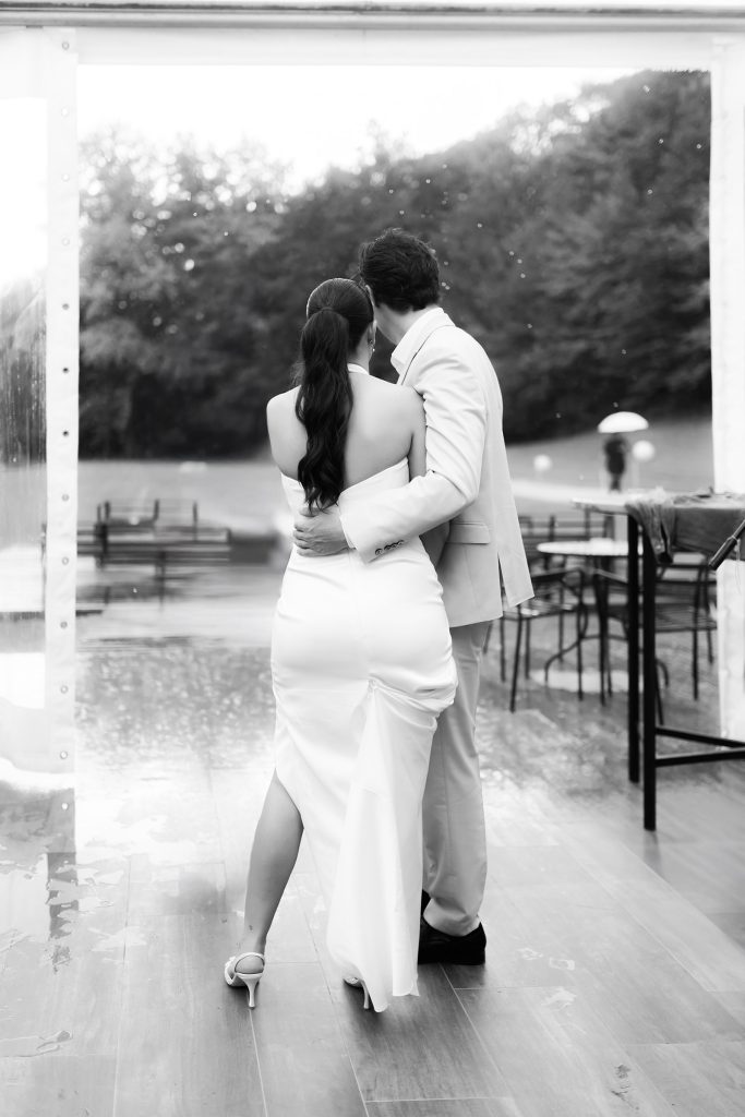 Bride and groom embracing during a rainy outdoor wedding in Istria